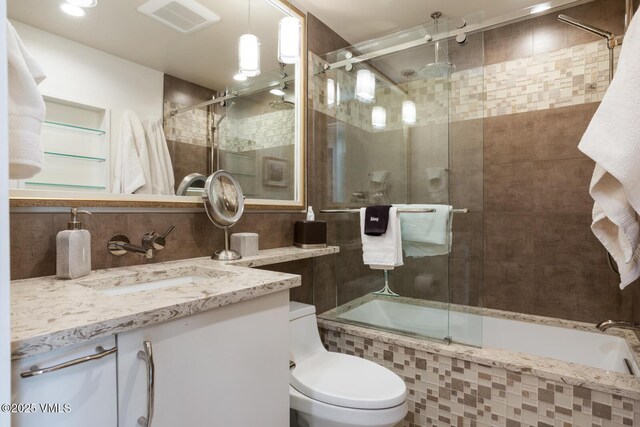 full bathroom featuring tasteful backsplash, enclosed tub / shower combo, vanity, and toilet