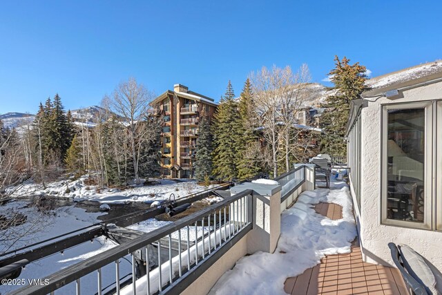 snow covered back of property with a mountain view