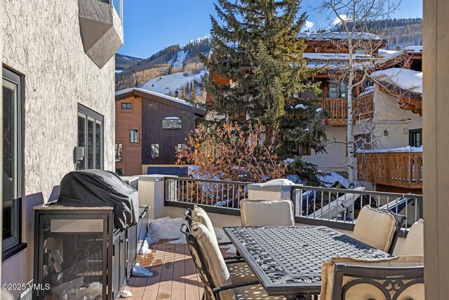 snow covered deck with a mountain view