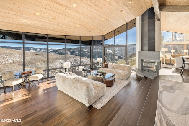 sunroom / solarium with a mountain view, wood ceiling, and plenty of natural light