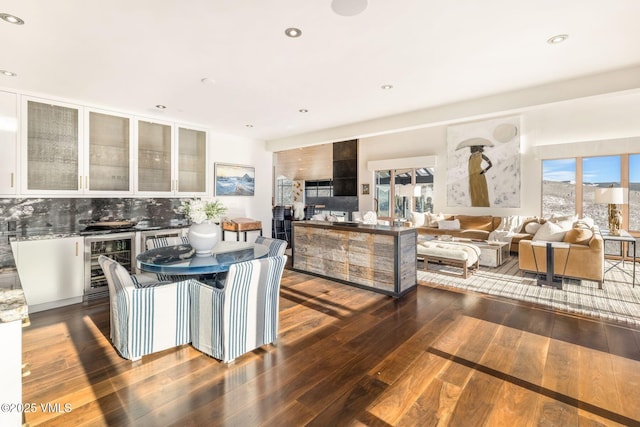 kitchen with white cabinetry, a wealth of natural light, beverage cooler, and dark hardwood / wood-style flooring