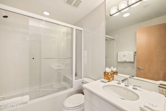 full bathroom featuring vanity, toilet, and combined bath / shower with glass door