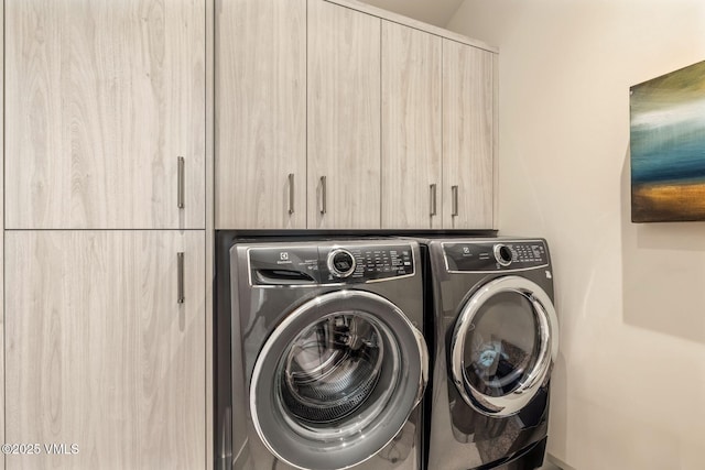 laundry area featuring independent washer and dryer and cabinets