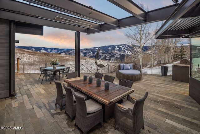 snow covered patio with a mountain view, an outdoor hangout area, and a pergola