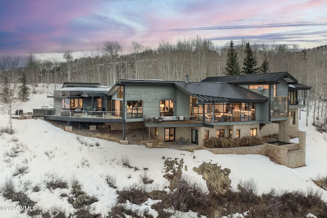 snow covered house featuring a balcony