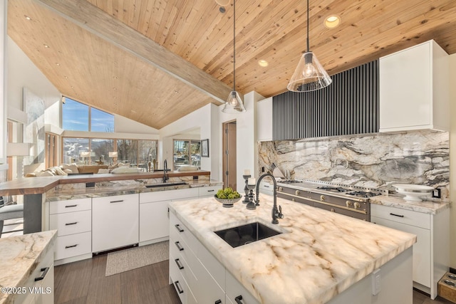 kitchen with pendant lighting, sink, an island with sink, and white cabinets