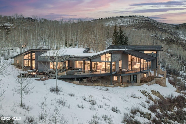 snow covered rear of property with a mountain view