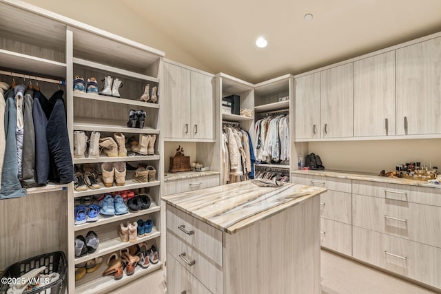 spacious closet featuring vaulted ceiling and light carpet