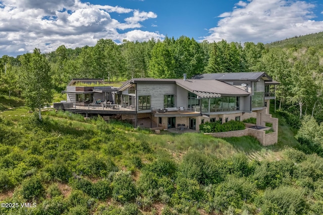 1268 Paintbrush, Avon, CO 81620 - back of house with a forest view, a deck, and a metal roof