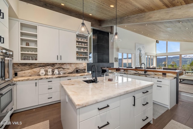 1268 Paintbrush, Avon, CO 81620 - kitchen featuring open shelves, a center island with sink, recessed lighting, backsplash, and white cabinets