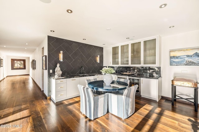 dining room with wine cooler, dark hardwood / wood-style floors, and indoor wet bar