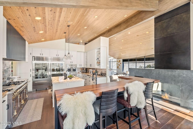 kitchen featuring tasteful backsplash, lofted ceiling with beams, white cabinets, wooden ceiling, and built in fridge