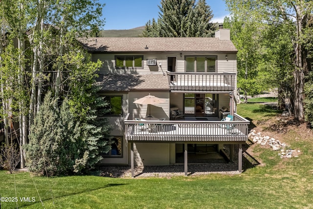 130 Grouse Ct Unit B, Avon, CO 81620 - back of house featuring a balcony, a shingled roof, a chimney, and a lawn