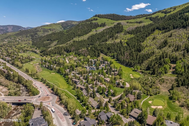 130 Grouse Ct Unit B, Avon, CO 81620 - aerial view of property's location featuring a heavily wooded area, mountains, and a golf course
