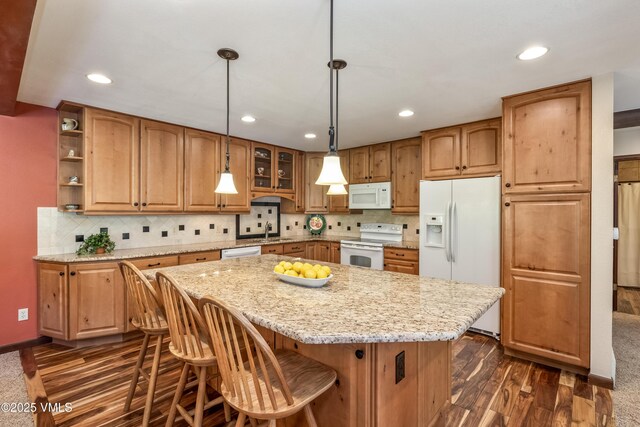 130 Grouse Ct Unit B, Avon, CO 81620 - kitchen with white appliances, dark wood finished floors, a center island, recessed lighting, and light stone counters