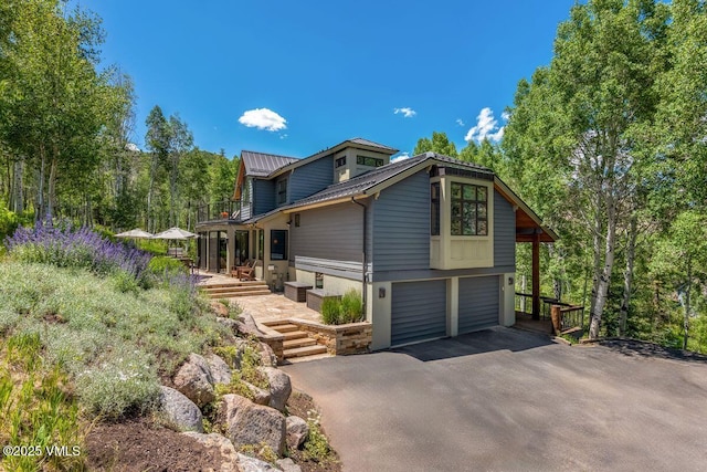 225 Eagle Crest Rd, Edwards, CO 81632 - view of property exterior with a garage, a metal roof, driveway, and a balcony