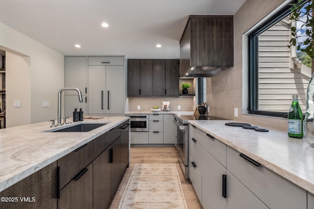 5074 Main Gore Dr S Unit B, Vail, CO 81657 - kitchen with stainless steel range with electric cooktop, dark brown cabinetry, wall chimney exhaust hood, recessed lighting, and light wood finished floors