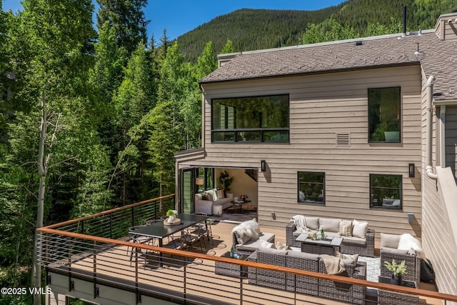 5074 Main Gore Dr S Unit B, Vail, CO 81657 - rear view of house with an outdoor living space, a view of trees, outdoor dining space, and a deck with mountain view