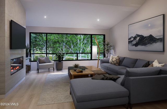 living room with vaulted ceiling, a large fireplace, and light hardwood / wood-style flooring