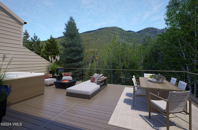 deck with a mountain view and an outdoor living space with a fire pit