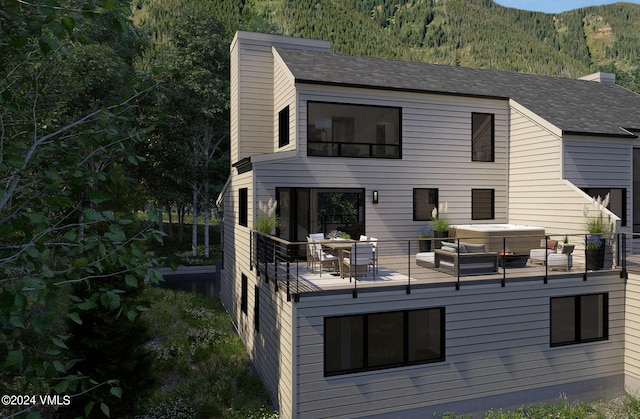 back of house featuring a hot tub and a mountain view