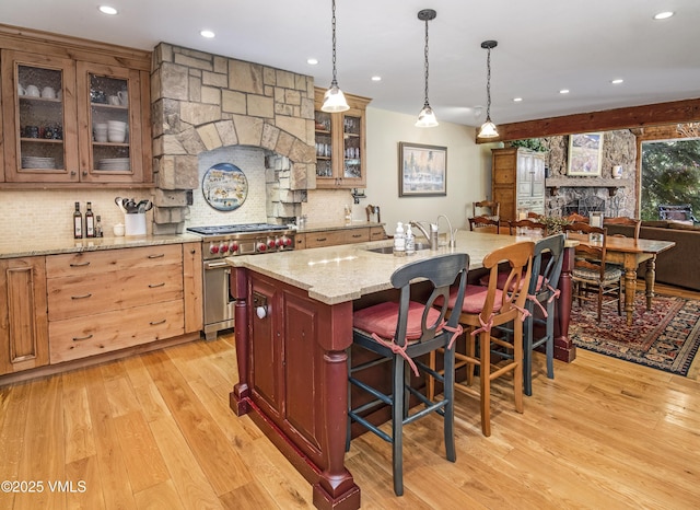 4030 Bighorn Rd Lot 1-B, Vail, CO 81657 - kitchen featuring premium range, a sink, light wood finished floors, a breakfast bar area, and tasteful backsplash