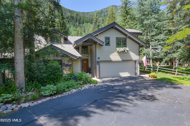 4030 Bighorn Rd Lot 1-B, Vail, CO 81657 - view of front of property featuring driveway, a garage, a shingled roof, a mountain view, and stone siding