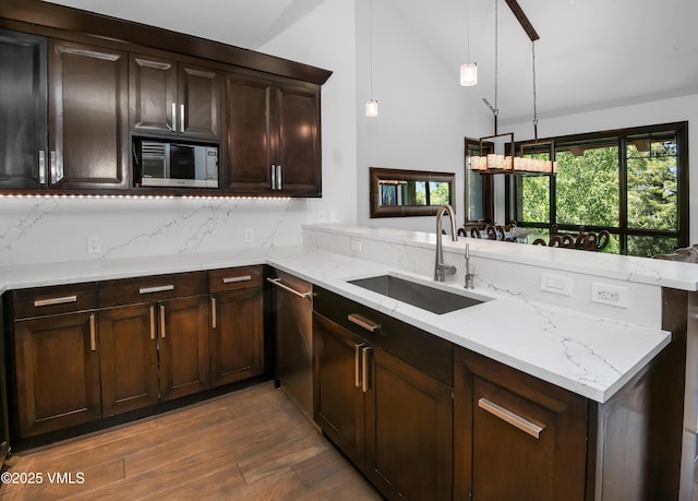320 Hummingbird Dr Unit A201, Avon, CO 81620 - kitchen with wood finished floors, vaulted ceiling, a peninsula, light stone countertops, and dark brown cabinetry