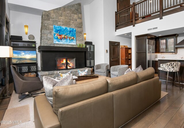 320 Hummingbird Dr Unit A201, Avon, CO 81620 - living area featuring wood finished floors, a stone fireplace, and a high ceiling