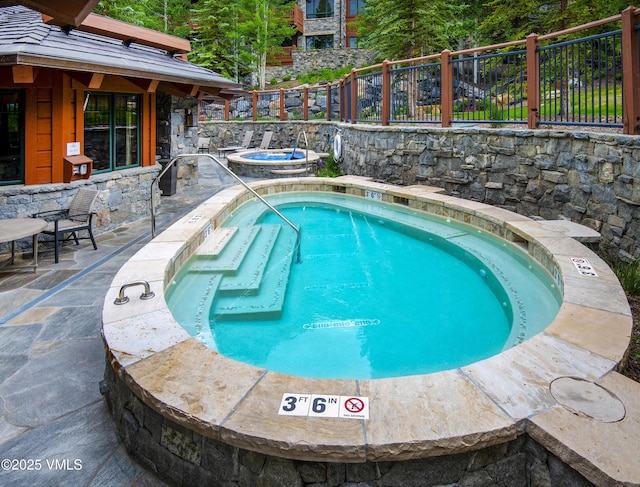 320 Hummingbird Dr Unit A201, Avon, CO 81620 - view of swimming pool featuring a fenced backyard, a pool, a patio, and a hot tub