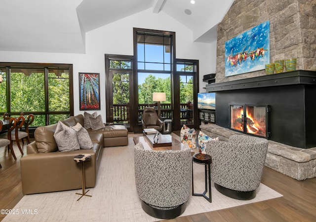 320 Hummingbird Dr Unit A201, Avon, CO 81620 - living area with high vaulted ceiling, wood finished floors, a fireplace, beamed ceiling, and healthy amount of natural light
