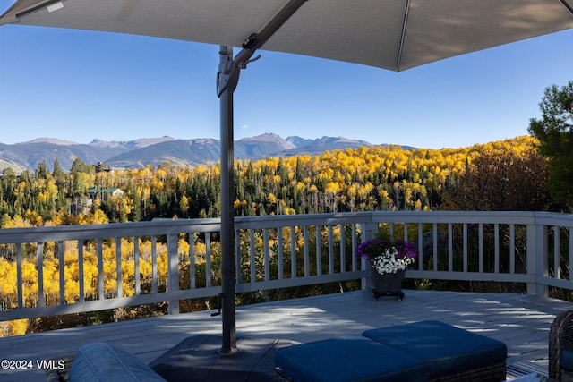 view of patio featuring a view of trees and a deck with mountain view