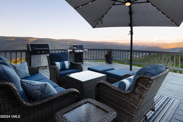 wooden deck featuring an outdoor living space, area for grilling, and a mountain view