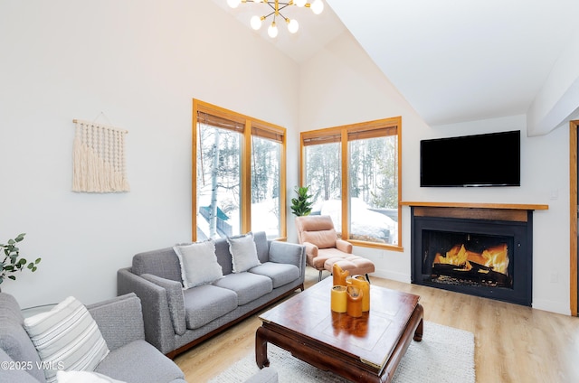 1610 Buffehr Creek Rd Unit A-22, Vail, CO 81657 - living area featuring a chandelier, high vaulted ceiling, light wood-type flooring, and a warm lit fireplace