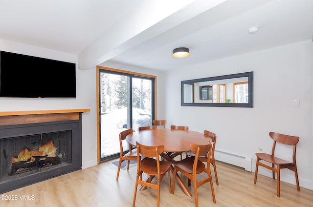 1610 Buffehr Creek Rd Unit A-22, Vail, CO 81657 - dining area with baseboard heating, light wood-type flooring, and a fireplace