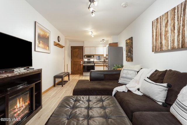 660 Lionshead Pl Unit 29, Vail, CO 81658 - living area featuring light wood-style floors and a glass covered fireplace
