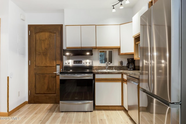 660 Lionshead Pl Unit 29, Vail, CO 81658 - kitchen with stainless steel appliances, under cabinet range hood, white cabinets, and light wood finished floors
