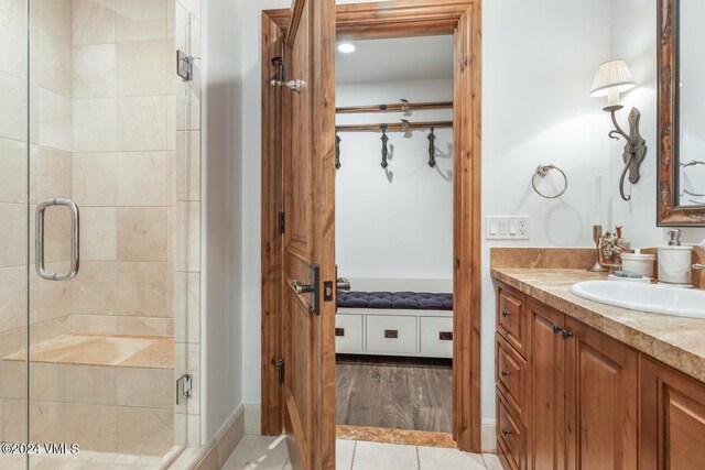 bathroom featuring tile patterned floors, vanity, and a shower with shower door