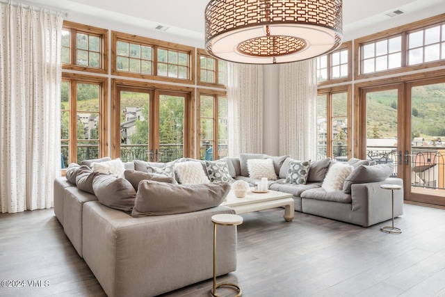 living room featuring french doors, a healthy amount of sunlight, and light wood-type flooring