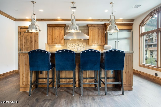 bar with a healthy amount of sunlight, dark hardwood / wood-style flooring, and hanging light fixtures