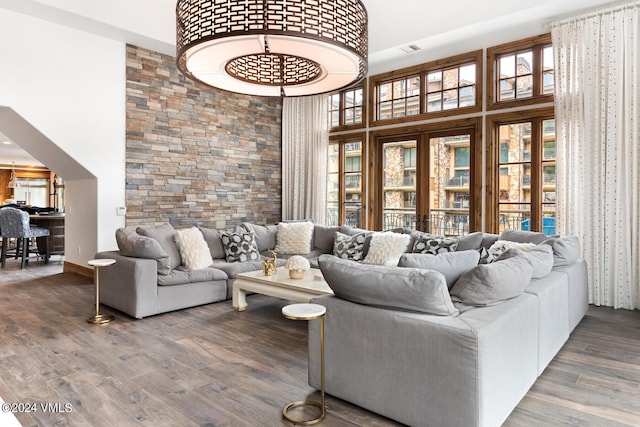 living room featuring a towering ceiling and dark hardwood / wood-style floors