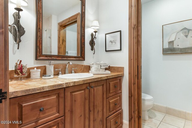 bathroom featuring vanity, tile patterned floors, and toilet