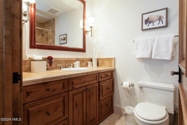 bathroom featuring tile patterned flooring, vanity, and toilet