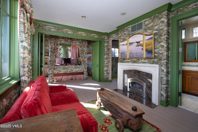 living room featuring a high end fireplace and wallpapered walls