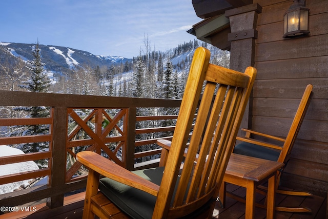 snow covered deck with a mountain view