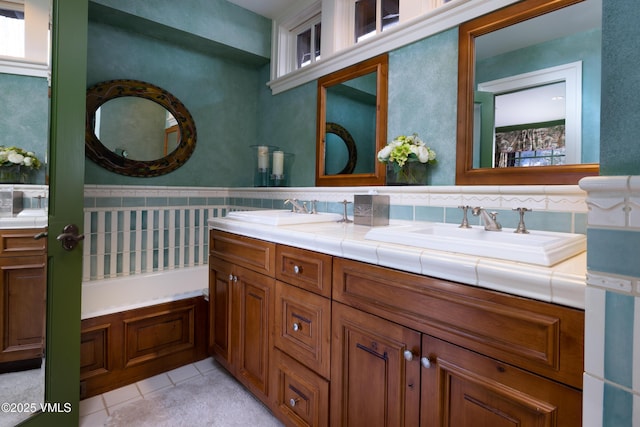 full bathroom with double vanity, tile patterned flooring, and a sink