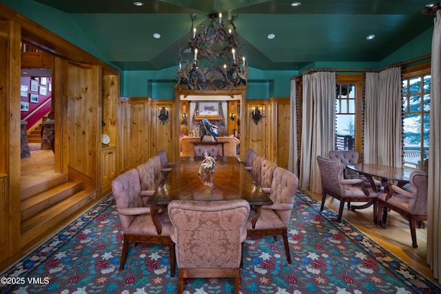 dining area featuring a notable chandelier, wood finished floors, recessed lighting, stairway, and lofted ceiling