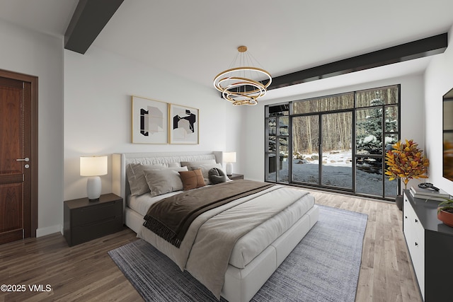 bedroom featuring a notable chandelier, baseboards, beam ceiling, and wood finished floors