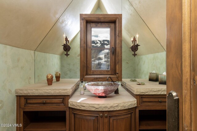 bathroom with lofted ceiling and vanity