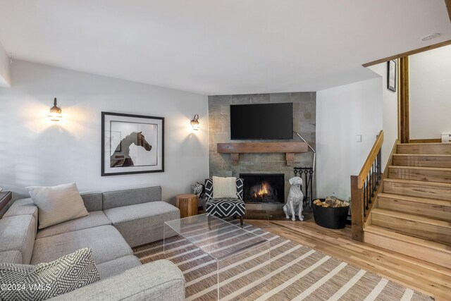 living room featuring hardwood / wood-style flooring and a stone fireplace